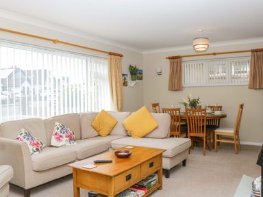 A living room with sofa and dining area at Halsdon Avenue in Exmouth