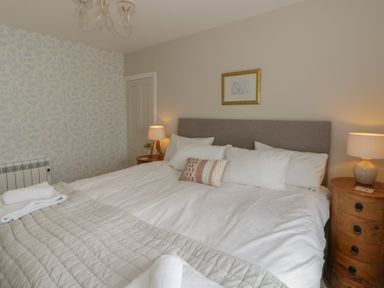 A bedroom with a bed and bedside lamps at Arosfa New Quay