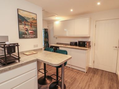 A kitchen with bar stools and kitchen appliances at Hidden Gem