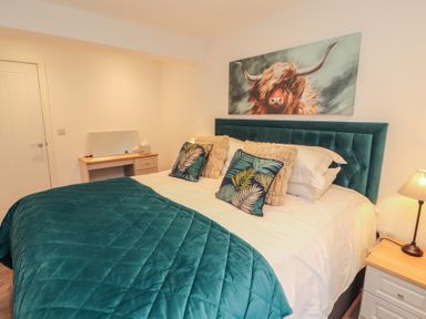 A bedroom with a bed, bedside table and lamp at Hidden Gem