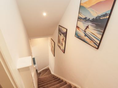 A staircase with framed art on the wall at Hidden Gem