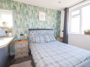 A bedroom with a bed and nightstand at Two Bed Apartment No.4 in Newquay