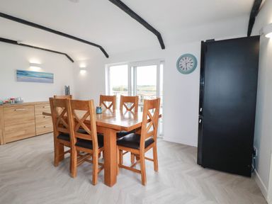 A dining room with a wooden table and chairs at Little House in Wadebridge