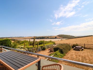 A view from a balcony overlooking fields and hills at Little House in Wadebridge