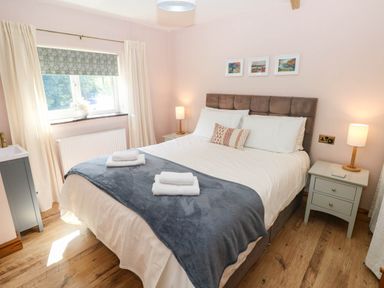 A bedroom with a bed and nightstand at The Old Dairy near Solva