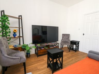 A living room with a television and seating area at Ocean Breeze in Weymouth