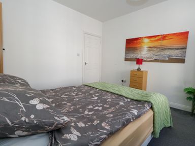 A bedroom with a bed and lamp at Ocean Breeze in Weymouth
