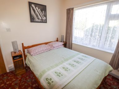 A bedroom with a bed and bedside table at Cottage 1 in Tenby