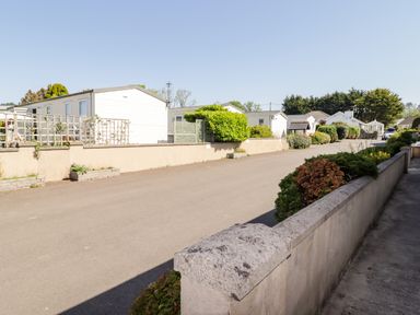 A view of mobile homes along a road at Cottage 1 in Tenby