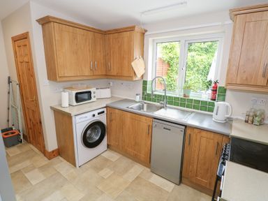 A kitchen with appliances and green tiles at Ti Maolla in Hollymount