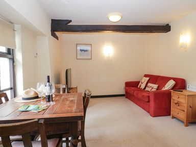 A living room with a dining table and sofa at Flat 4 Grasmere Lodge in Ambleside