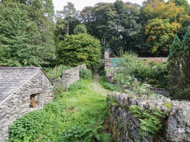 An outdoor area with stone walls and a path in Flat 4 Grasmere Lodge Ambleside