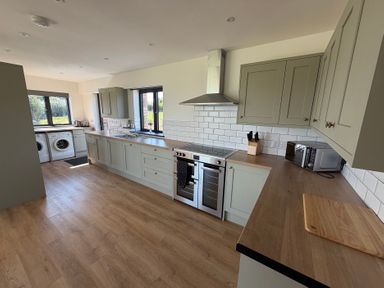 A kitchen with a washing machine and oven at High View Barn in Launceston