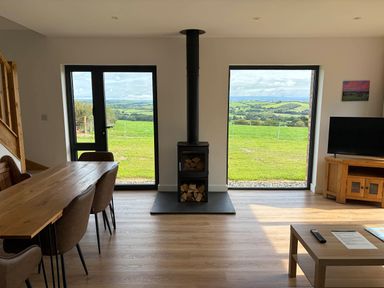 A living room with a dining table and wood stove at High View Barn in Launceston