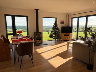 A living room with a dining table and views at High View Barn in Launceston