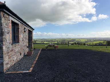 An outdoor seating area with a table and chairs at High View Barn in Launceston