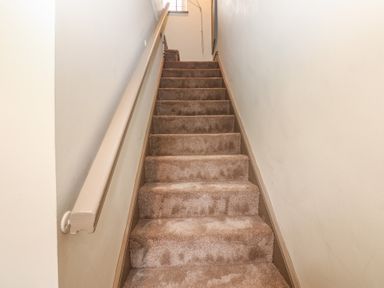 A staircase with carpet and handrail at Corner House in Wark