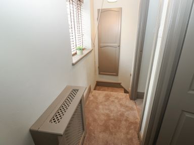 A hallway with a radiator and stairs at Corner House in Wark
