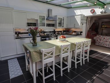 A kitchen with a counter and stools at 11b Market Street Narberth