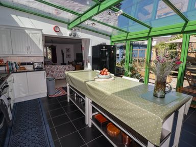 A kitchen with a central table and chairs at 11b Market Street, Narberth