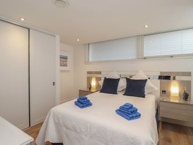 A bedroom with a bed and nightstands at 5 Sails in Dartmouth