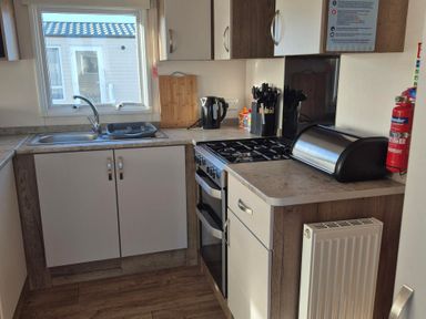 A kitchen with a sink, stove, and utensils at Unity Beach - Abi Ryedale in Burnham-on-Sea
