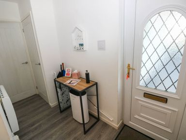 A hallway with a table and door at Coedrath Park