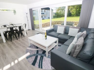 A living room with a sofa table and dining area at Coedrath Park