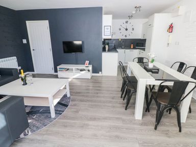 A living room with a sofa and dining area at Coedrath Park 