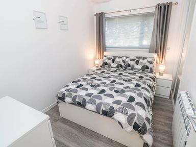 A bedroom with a bed and nightstands at Coedrath Park