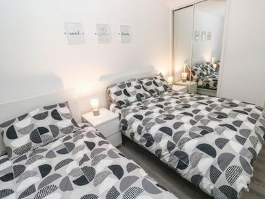 A bedroom with two beds and a bedside table at Coedrath Park