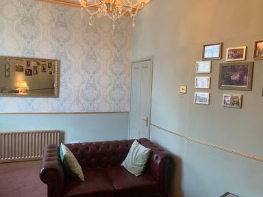 A living room with a sofa and mirror at Downton I in Alnwick