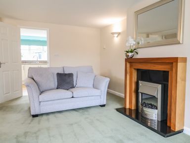 A living room with a sofa and a fireplace at Frome View Wool