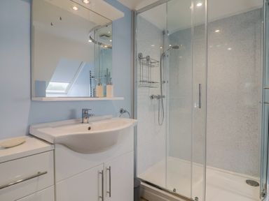 A bathroom with a sink, shower, and mirror at Frome View in Wool