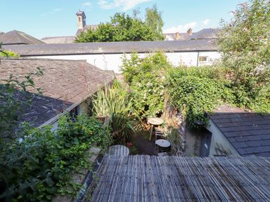A garden view with a table and chair at Scoops’ Nook in Caernarfon