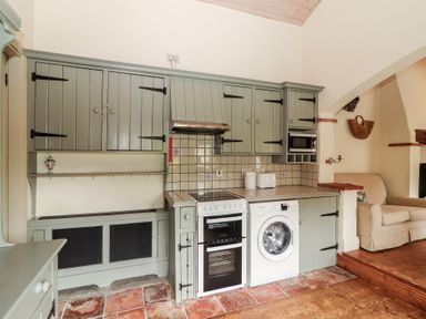A kitchen with appliances and cabinets at The Coach House Cottage in BALLYCOMMON