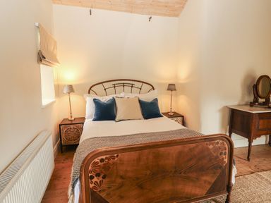 A bedroom with a bed and nightstands at The Coach House Cottage BALLYCOMMON