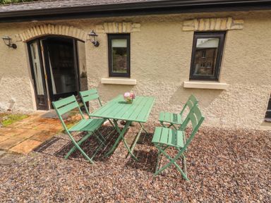 A table with chairs outside at The Coach House Cottage Ballycommon