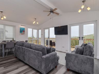 A living room with a sofa and dining table at Lodge 19 in Torpoint
