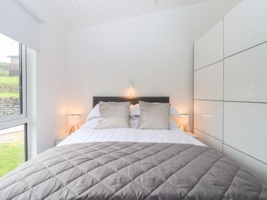 A bedroom with a bed and lamps at Lodge 19 in Torpoint