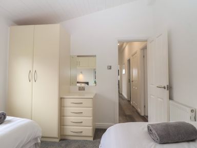 A bedroom with a wardrobe and chest of drawers at Lodge 19 in Torpoint
