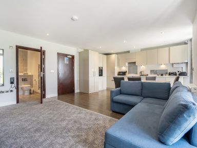 A living room with a sofa and kitchen area at Cotswolds Apartment, sleeps 4 in Chipping Norton