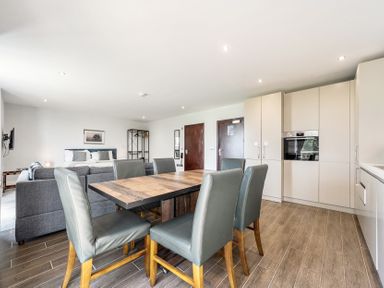 A living room and kitchen area with a dining table and sofa at Cotswolds Apartment, sleeps 4 in Chipping Norton