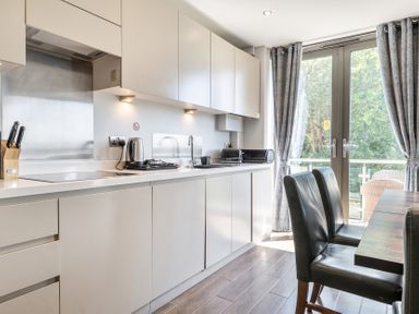 A kitchen with cabinets and a table at Cotswolds Apartment, sleeps 4 in Chipping Norton