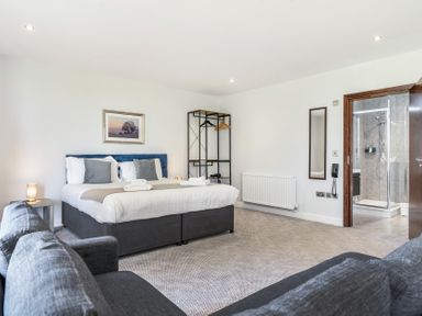 A bedroom with a bed and sofa at Cotswolds Apartment, sleeps 4, Chipping Norton