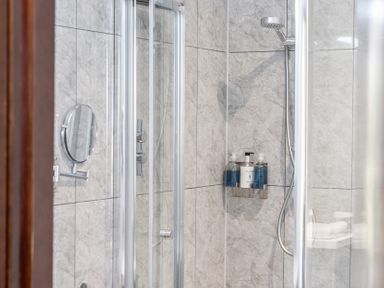 A shower with a mirror and soap dispenser at Cotswolds Apartment, sleeps 4 in Chipping Norton