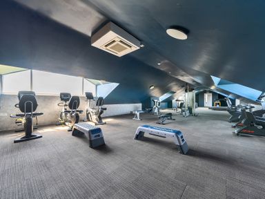 A gym with exercise bikes and weight bench at Cotswolds Apartment, sleeps 4, Chipping Norton