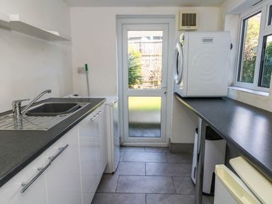 A utility room with a sink and washing machine at Driftmark in Weymouth