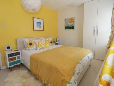 A bedroom with a bed and artwork at Driftmark in Weymouth