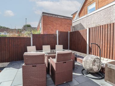 A garden with outdoor furniture and a hanging chair at Hafan Deg in Holywell